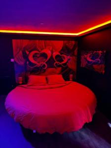 a bedroom with a bed with red lights at Love Room Passion in Saint-Hilaire-de-Talmont