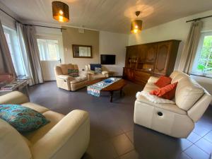 Sala de estar con 2 sofás y mesa en Heidebos, en Het Laar