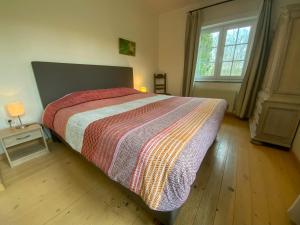 ein Schlafzimmer mit einem großen Bett und einem Fenster in der Unterkunft Heidebos in Het Laar