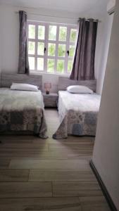 SO Green air lodge pereybere في بيريبير: غرفة نوم بها سريرين ونافذة