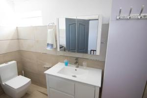 SO Green air lodge pereybere في بيريبير: حمام مع حوض ومرحاض ومرآة