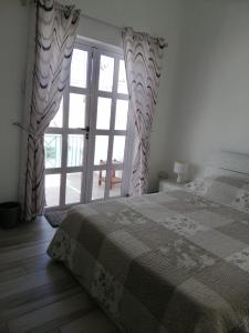 SO Green air lodge pereybere في بيريبير: غرفة نوم بها سرير ونافذة كبيرة