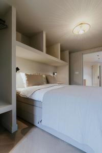 een slaapkamer met een groot wit bed en planken bij Havenhuis studio 1 in Tilburg
