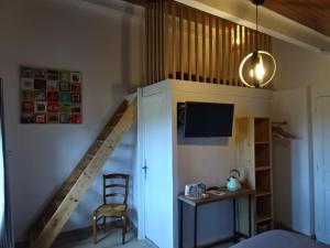 Habitación con escalera, escritorio y silla. en La Méridienne - Chambres d'hôtes, en Venterol