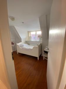 1 dormitorio con cama blanca y ventana en Erholung am Deich, en Glückstadt