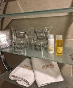 a glass shelf with towels and other products on it at Hotel Monte Cristo in Kotor