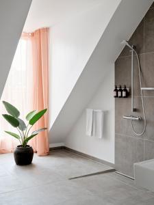 uma casa de banho com um chuveiro e um vaso de plantas em Aura Apartment Hotel em Arhus