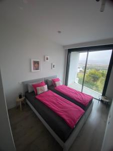 un letto in una camera con una grande finestra di Casa Melocotón - Designhouse mit privatem Pool, direkt am Golfplatz a Caleta de Velez