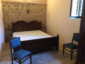 1 Schlafzimmer mit einem Bett und 2 Stühlen in der Unterkunft Villa Maros in Scicli