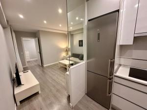 cocina con nevera y sala de estar. en Far Home Gran Vía, en Madrid 95 fotos más