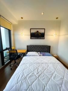 a bedroom with a large white bed and a desk at Luxury 2BR Penthouse in Gramercy, Makati in Manila