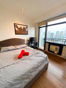 a bedroom with a large bed and a large window at Luxury 2BR Penthouse in Gramercy, Makati in Manila