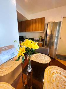 a kitchen with a table with yellow flowers in a vase at Luxury 2BR Penthouse in Gramercy, Makati in Manila