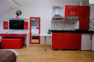 una cocina roja con armarios rojos y fregadero en Taksim Green Suites, en Estambul