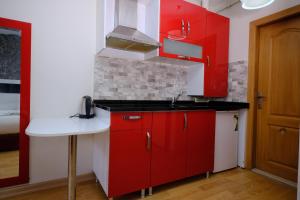 a kitchen with red cabinets and a sink at Taksim Green Suites in Istanbul