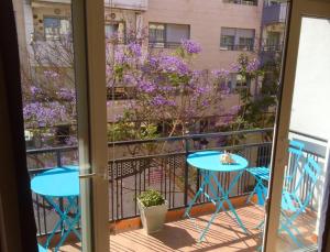 balkon ze stołem, krzesłami i fioletowymi kwiatami w obiekcie Ramon - Y - Cajal w mieście Fuengirola