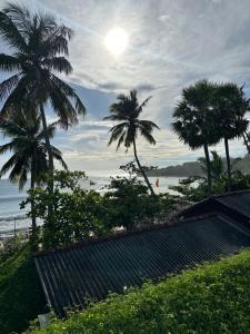 een uitzicht op een strand met palmbomen en de oceaan bij Arugambay Surf Resort in Arugam Bay