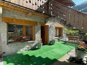 聖福特亨太斯的住宿－Le murmure de l'Isère，一个带绿色草地和木楼梯的庭院
