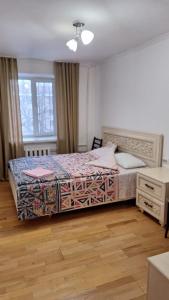 a bedroom with a bed and a dresser at У Тахира in Almaty