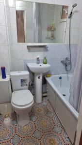 łazienka z toaletą, umywalką i wanną w obiekcie У Тахира w mieście Ałma-Ata