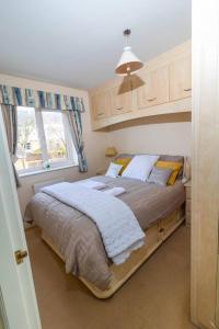 Schlafzimmer mit einem großen Bett und einem Fenster in der Unterkunft Cosy 3 bedroom house in Stoke on Trent