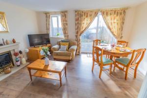 ein Wohnzimmer mit einem Tisch und Stühlen sowie ein Esszimmer in der Unterkunft Cosy 3 bedroom house in Stoke on Trent