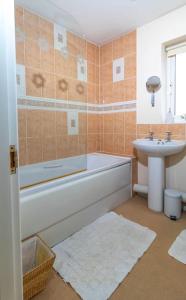 La salle de bains est pourvue d'une baignoire et d'un lavabo. dans l'établissement Cosy 3 bedroom house, à Stoke-on-Trent