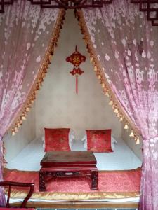 a bedroom with a bed with a red curtain at Pingyao Yan Family Homestay in Pingyao