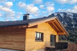 a house with a roof with a chimney on it at Ferienwohnung Alexander Kleinheinz in Rettenberg