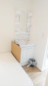 ein weißes Badezimmer mit einem Waschbecken und einem Spiegel in der Unterkunft Hananogo Ikebukuro - Vacation STAY 09224v in Tokio