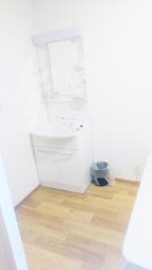 a white bathroom with a sink and a wooden floor at Hananogo Ikebukuro - Vacation STAY 16064v in Tokyo