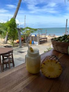 a jar of pineapple sauce on a table next to a basket of fruit at Arugambay Surf Resort in Arugam Bay