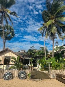 un restaurante en la playa con palmeras en Arugambay Surf Resort, en Arugam Bay