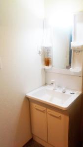 a bathroom with a white sink and a mirror at Hananogo Ikebukuro - Vacation STAY 16082v in Tokyo