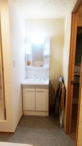 ein kleines Bad mit einem weißen Waschbecken in einem Zimmer in der Unterkunft Hananogo Ikebukuro - Vacation STAY 16082v in Tokio