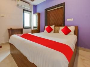 a bedroom with a large bed with red and white sheets at OYO Flagship BABLU GRAND IN HOTEL in Hyderabad
