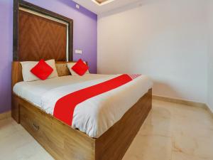 a bedroom with a large bed with red pillows at OYO Flagship BABLU GRAND IN HOTEL in Hyderabad