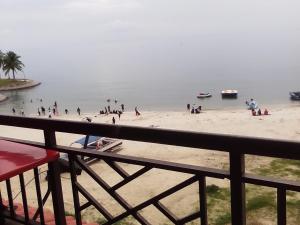 un groupe de personnes sur une plage près de l'eau dans l'établissement PD Corus myHoliday Homes & Apartments, à Port Dickson