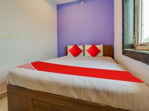 a bedroom with a large bed with red pillows at OYO Flagship BABLU GRAND IN HOTEL in Hyderabad