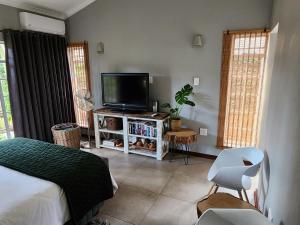 a bedroom with a bed and a flat screen tv at Bendor Garden Flat in Polokwane