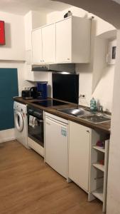a kitchen with white cabinets and a sink and a dishwasher at 1-Zimmer Gartenwohnung in Speyer in Speyer