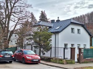 zwei Autos, die vor einem weißen Haus geparkt sind in der Unterkunft Apartment in Purkersdorf bei WienTop 3 in Purkersdorf