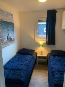 1 dormitorio con 2 camas y ventana en Family friendly holiday home en Hulshorst