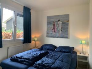a bedroom with a bed and a painting on the wall at Family friendly holiday home in Hulshorst