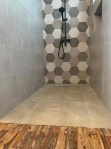 a bathroom with a shower with a checkerboard wall at Villa Kamaya, Chamarel in Chamarel