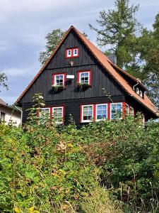 a black house with red shutters at Haus Erna Schierke in Schierke