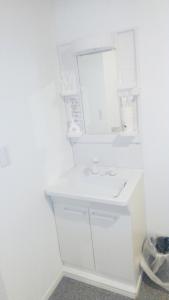 een witte badkamer met een wastafel en een spiegel bij Hananogo Ikebukuro - Vacation STAY 16098v in Tokyo