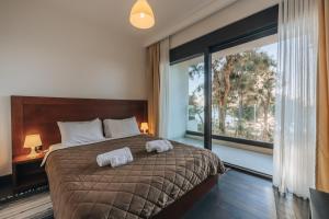 a bedroom with a large bed with two towels on it at Apartments Kuce Lekovica Beach & snack bar- Bistro in Bar