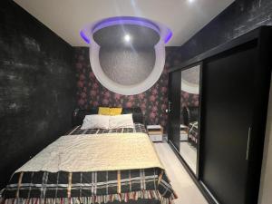a bedroom with a bed and a purple ceiling at Cozy Apartmen with Garden in Sheikh Zayed in Sheikh Zayed