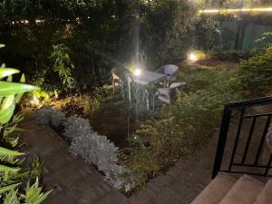a table and chairs in a garden at night at Cozy Apartmen with Garden in Sheikh Zayed in Sheikh Zayed